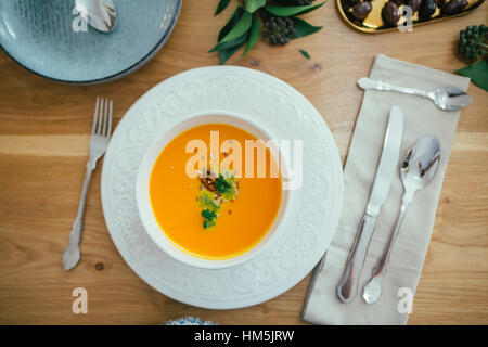 Vista aerea di zuppa di zucca nella ciotola sul tavolo da pranzo Foto Stock