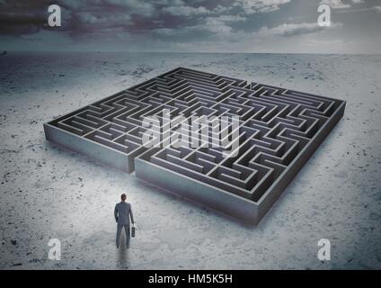 Imprenditore in piedi di fronte ad un labirinto Foto Stock