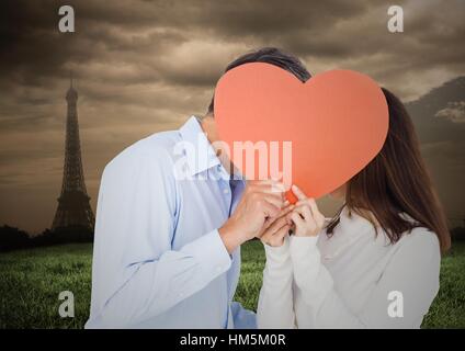 Coppia romantica nascondendo loro faccia dietro il cuore Foto Stock