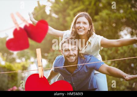 L uomo dando un piggyback ride per donna Foto Stock