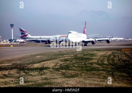 Gli aerei della coda per una slot di decollo all'Aeroporto di Londra Heathrow Foto Stock