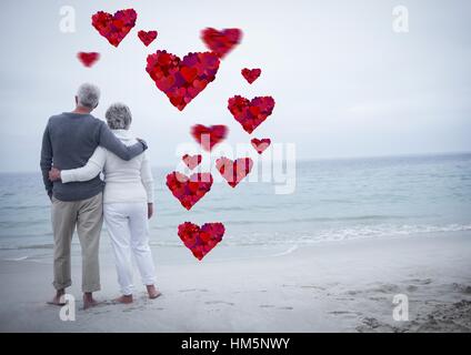 Coppia senior che abbraccia ogni altro in spiaggia Foto Stock