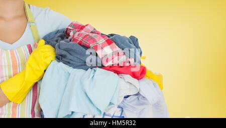 La sezione centrale della donna tenendo la benna piena di vestiti Foto Stock