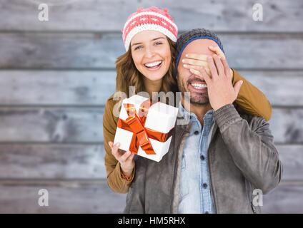 Donna che copre le mans occhi mentre i regali Foto Stock