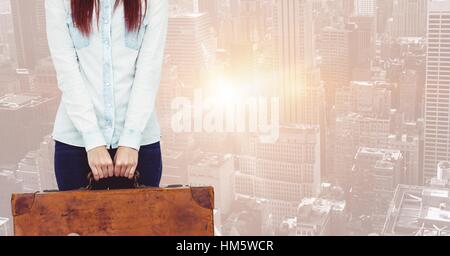 Donna valigia di contenimento contro sfondo blu Foto Stock