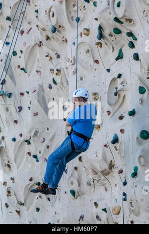 Uomo di mezza età sulla parete di arrampicata Foto Stock