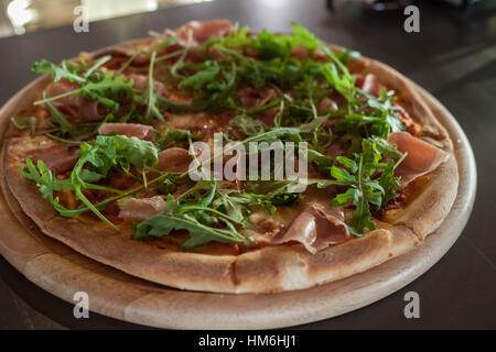 Pizza sottile crosta con foglie di rucola Foto Stock