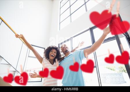 Giovane abbracciando a casa con appesi cuori attorno Foto Stock