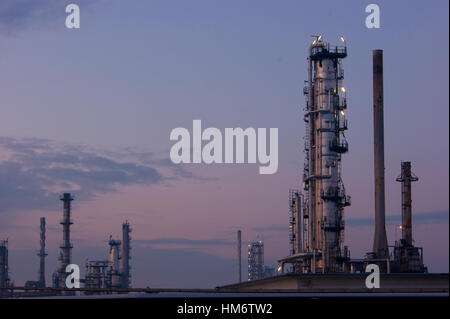 Flue-stack di gas di canne fumarie in acciaio in un Amoco in disuso / Tamoil olio impianto di raffineria di Cremona, Italia, al crepuscolo Foto Stock