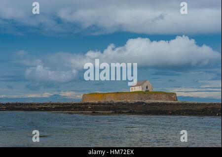 Cwyfan chiesa La chiesa in mare anglesy. La chiesa aveva una muraglia difensiva costruita intorno ad esso per impedire errosion, ora si siede da solo nella baia di cut off Foto Stock