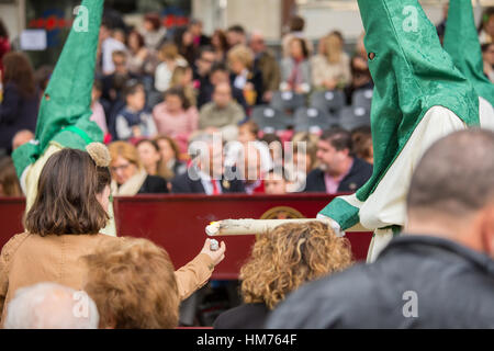 MALAGA, Spagna - 20 marzo: Un nazareno dà cera di candela ad una ragazza non identificato nella processione della Domenica delle Palme (Pollinica) il 20 marzo 2016 in Malag Foto Stock