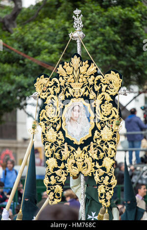 MALAGA, Spagna - 20 Marzo: Nazareni tenendo un banner della Vergine Maria nella processione della Domenica delle Palme (Pollinica) Foto Stock