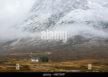 Cottage scozzese sotto una montagna innevata lato vicino a Glencoe,Scozia Scotland Foto Stock