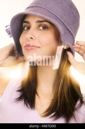 Ritratto di metà donna adulta cercando sul berretto lavorato a maglia Foto Stock