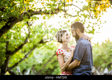 Giovane abbracciando in Cherry Orchard Foto Stock