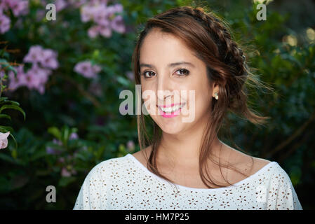 Ritratto di donna con capelli intrecciati outdoor con la luce solare Foto Stock