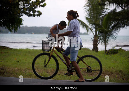 Madre con il suo bambino in una bicicletta. Bocas del Toro, Panama. Bocas del Toro (significato "sud del Bull') è una provincia di Panama. La sua area è 4,643.9 sq Foto Stock