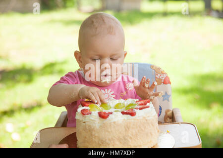 Un bambino di mangiare una torta di compleanno con le mani Foto Stock