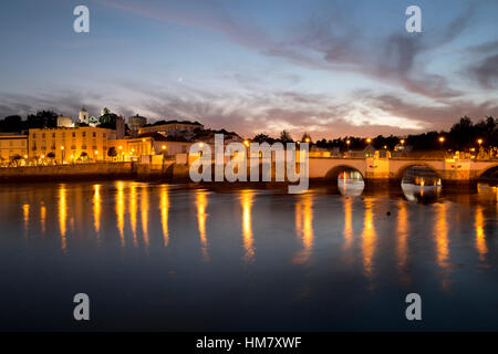 Sette arcate del ponte romano e la città sul Rio fiume Gilao di notte, Tavira, Algarve, Portogallo, Europa Foto Stock