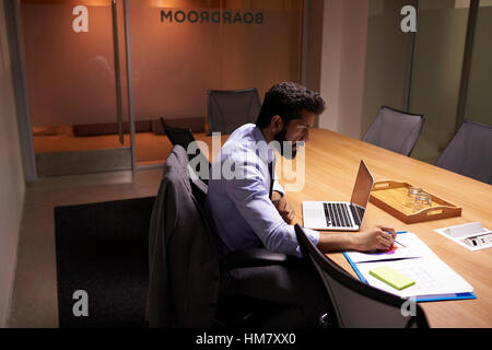 Imprenditore ispanica lavora fino a tardi in ufficio, vista in elevazione Foto Stock