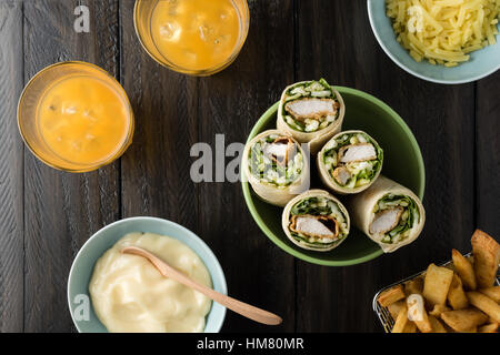 Pollo Impanato burrito avvolgere con lattuga fresca formaggio su sfondo rustico Foto Stock