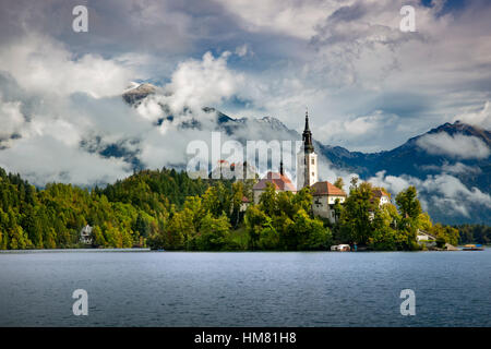 Chiesa di Santa Maria Assunta a Bled isola del lago di Bled con il castello di Bled al di là, Bled, Alta Carniola, Slovenia Foto Stock