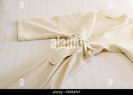 Accappatoio bianco sul letto Foto Stock