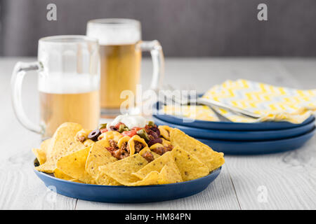 Carni bovine nachos con birre su sfondo rustico Foto Stock