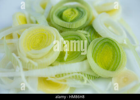 I porri tagliati a fettine sottili anelli su una piastra bianca ad essere utilizzato per un ingrediente Foto Stock