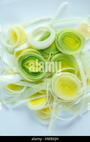 I porri tagliati a fettine sottili anelli su una piastra bianca ad essere utilizzato per un ingrediente Foto Stock