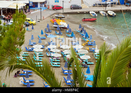 Bali, Grecia - 30 Aprile 2016: Mithos sabbiosa spiaggia di Baia Mare del villaggio resort Bali. Viste della riva, lavato da onde e sdraio con ombrelloni wh Foto Stock