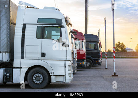 Autocarri pesanti carichi di merci rimorchi parcheggiati in area di attesa sul confine di stato attraversamento. Disco internazionale trasporti e logistica. I trasporti Foto Stock