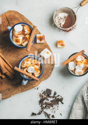 Cioccolata calda in smalto tazze con cannella e torrefatto marshmallows Foto Stock
