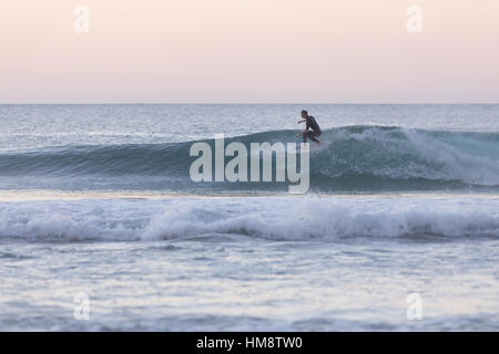 Il corpo del surfista a cavallo di un onda perfetta. Foto Stock