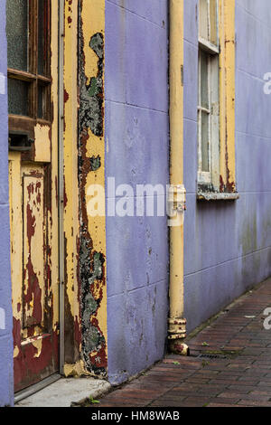 Peeling vernice sul portale e la facciata della casa di porpora e giallo Foto Stock