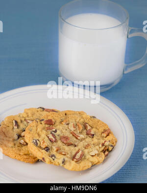 Freschi di forno chocolate chip cookies alle noci pecan su una piastra bianca su un posto blu mat. Stati Uniti d'America. Foto Stock