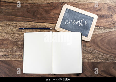 Aprire plain pagina vuota notebook con matita e lavagna su tavola in legno rustico Foto Stock
