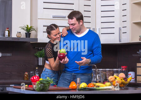 Bella coppia Giovane mangiare insieme apple in cucina Foto Stock