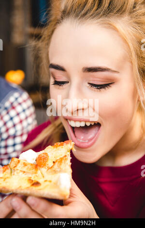 Donna di mangiare la pizza Foto Stock