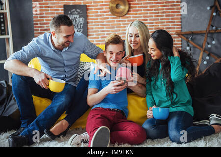 Ritratto di gruppo di allegro vecchi amici di comunicare gli uni con gli altri, amico in posa sul cafe, stile urbano di persone aventi il divertimento, concetti riguardanti la gioventù stare insieme allo stile di vita. Wifi connesso Foto Stock