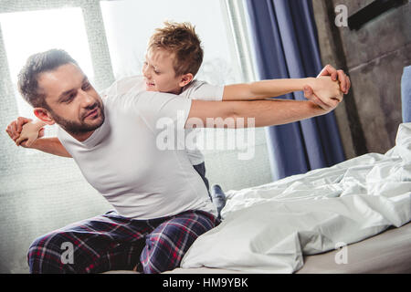 Felice padre e figlio sul letto Foto Stock