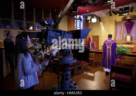 Watertown, Massachusetts, STATI UNITI D'AMERICA. 22 Mar, 2016. Padre SINISA (destra) passeggiate per l'altare della cappella CatholicTV a dire Messa per gli spettatori da Watertown, Massachusetts. 29-anno-vecchio reverendo SINISA UBIPARIPOVIC è un vicario parrocchiale a san Paolo parrocchia a Hingham, Massachusetts. Mentre studiava all'Università di Bentley, andò a vedere il Papa Benedetto a New York e a un rally sperimentato 'un improvviso schiacciante senso di desiderio di servire Dio in modo più così totale'. Quello fu l inizio del suo desiderio di diventare sacerdote. Credit: Alena Kuzub/ZUMA filo/ZUMAPRESS.com/Alamy Live News Foto Stock