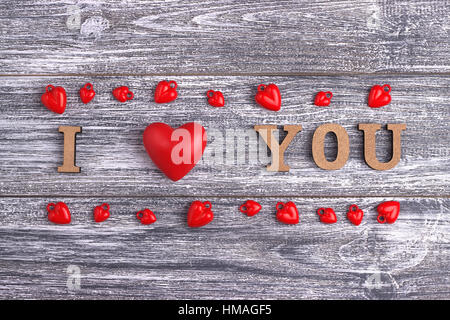 Ti amo, di legno con cuore rosso scritte, grigio Sfondo di legno, cartolina felice il giorno di San Valentino, laici piatta Foto Stock