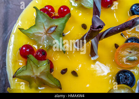 Giallo jelly cheesecake con frutti di bosco su piastra Foto Stock