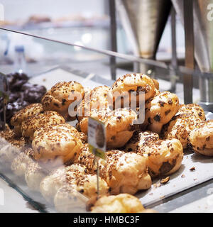 Vicino sul gruppo di Macadamia fresco rotolo nel panificio Foto Stock