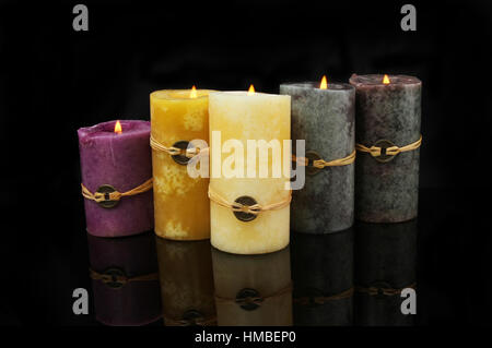 Gruppo di combustione 5 Feng Shui candele in rappresentanza di metallo, Terra, Legno, Acqua e Fuoco, con riflessioni contro uno sfondo nero Foto Stock