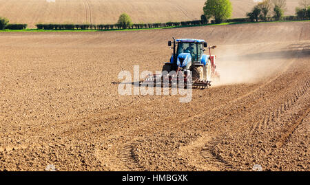 Il trattore rastrellando un campo arato in primavera pronto per piantare un raccolto Foto Stock