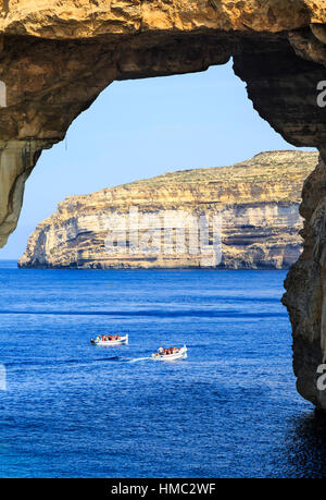 Escursione di barche che viaggiano attraverso la finestra azzurra arco naturale a Gozo, Malta Foto Stock