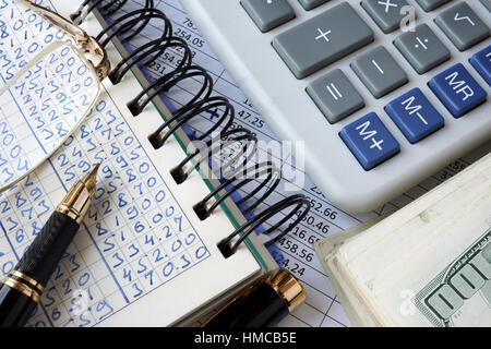 Ledger, calcolatrice e denaro. Il concetto di business. Foto Stock