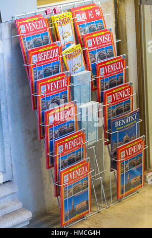 Guida di viaggio di libri in diverse lingue per la vendita sul display in rack a Venezia, Italia nel mese di gennaio Foto Stock